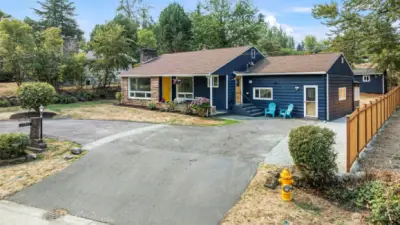Fresh exterior paint, Goldfinch-yellow door, and side-entry seating add personality and welcome.
