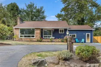 Classic mid-century charm with sandstone planter beds, layered textures, and vinyl windows with future upgrade potential.