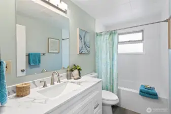 Fully updated full bath with new vanity, fixtures, LVP flooring, and ceiling-height subway tile—clean, calm, and timeless.