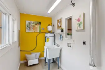 Tucked off the flex room, the dedicated laundry area features cheerful light, a utility sink, and hookups for a side-by-side washer and dryer. A sunny window brightens the chore zone, while a bold pop of color adds personality and warmth.
