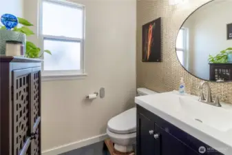 Fully updated half bath with new tile, vinyl tile floor, baseboards, vanity, sink, faucet, mirror, lighting, toilet and heated bidet.