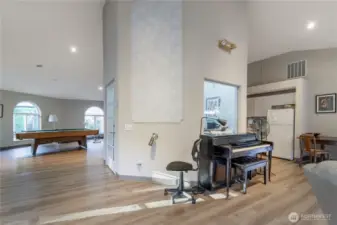 Clubhouse piano and a peek to the kitchen beyond. This space can be used by the community as well as reserved for private gatherings.