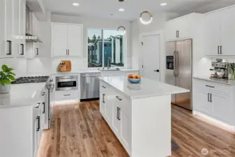 Expansive kitchen with gas cooktop. Virtually staged.