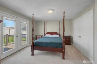 Primary bedroom and French doors to deck and pool area in back yard