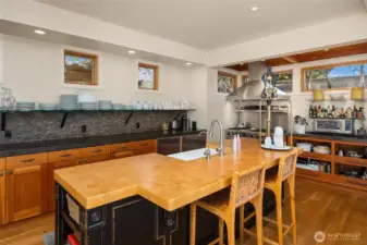 Hardwoods floors and custom cabinetry with open shelving and a great island for gathering.