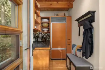 The back pantry with storage and fridge.