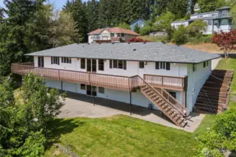 West side of home with expansive deck and daylight basement.
