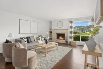 Living room with woodburning fireplace and territorial views over Interbay Golf Course and Queen Anne Hill.
