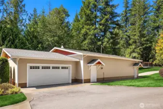 Detached garage has another garage door on the south side of the building with a carport in back.