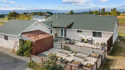 Large patio and covered hot tub area next to the raised garden bed!