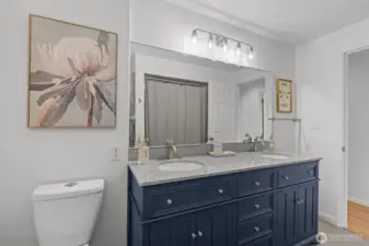 Updated bathroom featuring a quartz countertop, new lighting, and a modern mirror.