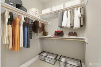Walk-in closet on one side of the aisle and wardrobe on the other.