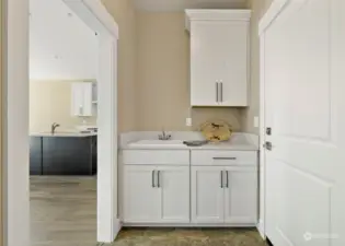 Utility room cabinets and sink with washer dryer space on other side