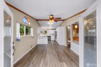 Entering through the French doors into flex space, kitchen and dining area