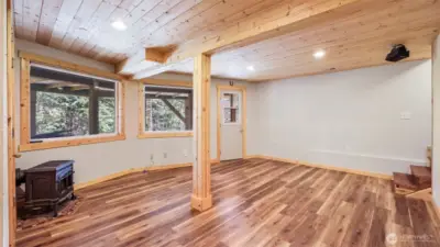 Finished lower level features luxury vinyl plank flooring and access out to under the deck.