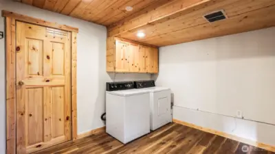 Washer and dryer located in the finished basement. Door to the left leads to a large storage room and to the far left (not shown) is a open closet area.
