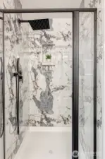 Shower in primary bath has rain head and handheld sprayer.