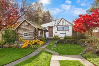 Fully fenced backyard with detached shop and log shed.