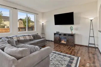 Living room with big windows to let in lots of natural light, plus engineered hardwood floors floors run throughout the main level