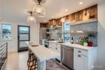 The back splash is an artistic mosaic tile arrangement...  All the appliances you need, including a waste/recycling cabinet drawer.