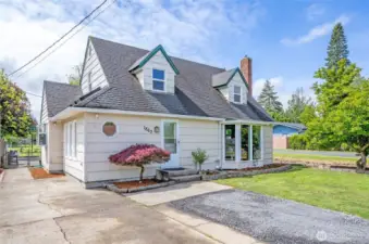 Charming Cape Cod-style home in Chehalis’ desirable Snively district, featuring a manicured lawn, updated windows, fresh landscaping, and classic dormer windows that give it timeless curb appeal. The large bay window and brick chimney add warmth and character.