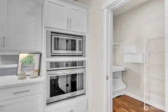 Wall oven & Build-in microwave off of the large walk-in pantry with built-in shelving.