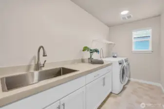 Large galley-style landry room with sink and foling area.
