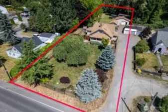 1+ acre Lot with two driveways, a detached shop/garage, 1 car detached garage, covered RV parking, shed, and so much more!!