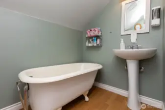 Upstairs 3/4 bath features sink, toilet and stand-alone tub