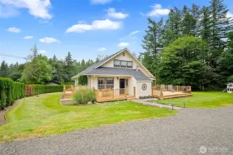 Charming country-style home nestled on a beautifully manicured lot with wraparound deck—perfect for relaxing or entertaining in serene privacy.
