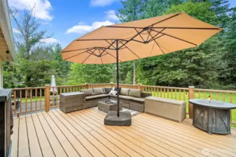 Enjoy serene outdoor living on this beautifully finished deck all surrounded by peaceful greenery.