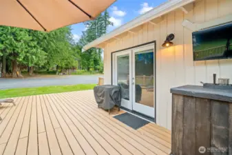 Step out through elegant French doors onto a spacious deck—perfect for grilling, relaxing under the trees, or catching the game