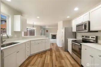 Kitchen with brand new appliances, quarters countertop, freshly painted cabinets, and brand new appliances.
