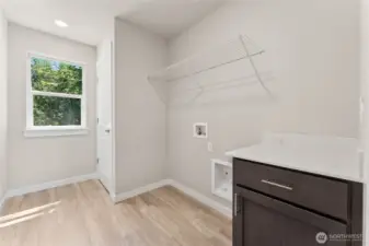 Laundry room with linen closet and folding countertop and cabinets. Photo's are for representational purposes only. Colors and finishes may differ.