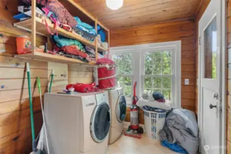 Fir/pine lined utility room. Door leads out to deck.