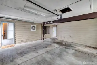 Inside view of the oversized 2 car garage. Access door from driveway into the garage along with the electronic garage door. Room for cars and toys!