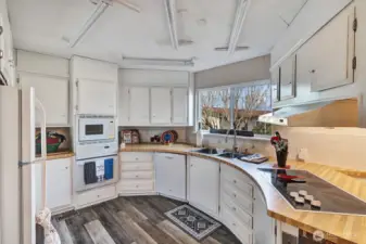 Circular style kitchen has butcher block style counter tops. Plenty of prep and storage space. Ample cabinets and drawers for all your cooking necessities.Garden window view from the double, stainless steel sink with upgraded faucet.