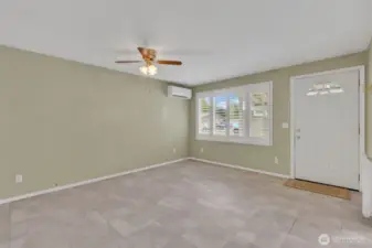 Living room with ceiling fan and mini split. Elegant faux wood shutter blinds.