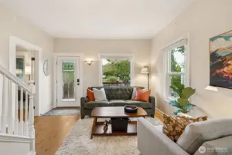 Welcome through the lead glass front door into a bright, inviting entryway. Vinyl windows throughout bring in natural light, and a main floor bedroom to the right of the front door.