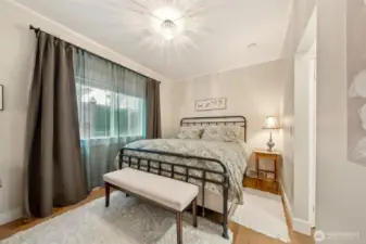 The primary suite offers LVP flooring that flows seamlessly throughout, accented by large baseboard trim and a touch of crown molding. Timeless lighting enhances the room’s charm, while the attached 3/4 bath adds convenience and privacy.