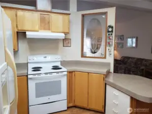 Anther View of the Nice Well Kept U Shaped Kitchen with Newer Appliances, Counter Tops, Laminate Flooring Showing Cathedral Ceilings and a Breakfast Eating Bar.
