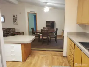 Opposite View of the Nice Well Kept U Shaped Kitchen with Newer Appliances, Counter Tops, Laminate Flooring Showing Cathedral Ceilings and a Breakfast Eating Bar Showing the Dining Room.