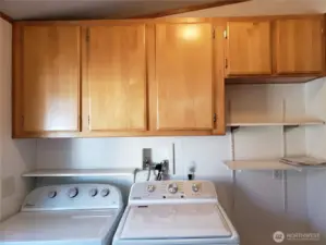 Another Picture of the Large Utility Room with Newer Washer, Dryer, 3 Shelves and 5 Storage Cabinets.