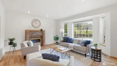 Natural light pours through expansive windows, brightening this beautiful front sitting room.