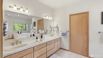Spacious primary ensuite featuring a dual-sink vanity with ample storage and bright, clean finishes