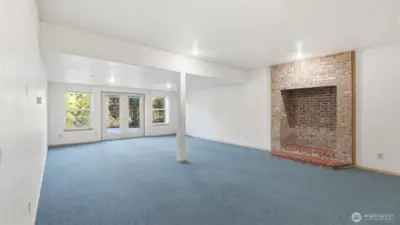 Comfortable and flexible lower-level space with a statement brick fireplace and room to spread out