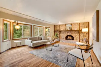 Large picture windows, warm hardwoods, and a brick wall center piece make this living room a place you'll want to enjoy.