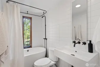 Bathroom with large soaking tub and sleek tile work, bamboo greenery