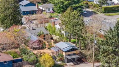 Aerial photo from back alley showing detached garage and studio structure, backyard, and back of house