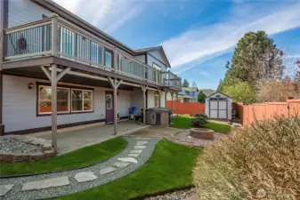 Fully fenced backyard with firepit, hot tub, garden shed, covered patio and upper deck